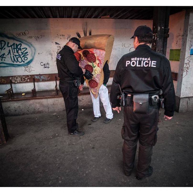 Městská policie pokutuje pizzu za poruseni zákazu kouření na zastávce v Praze na Smíchově.